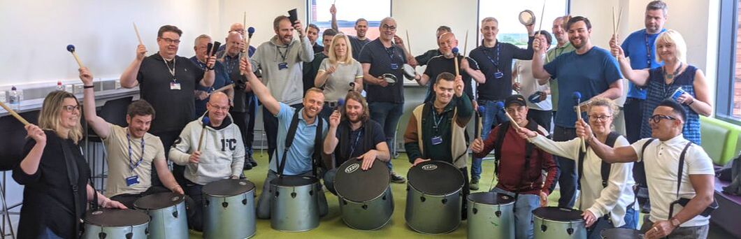 Staff group drumming at a business wellbeing event