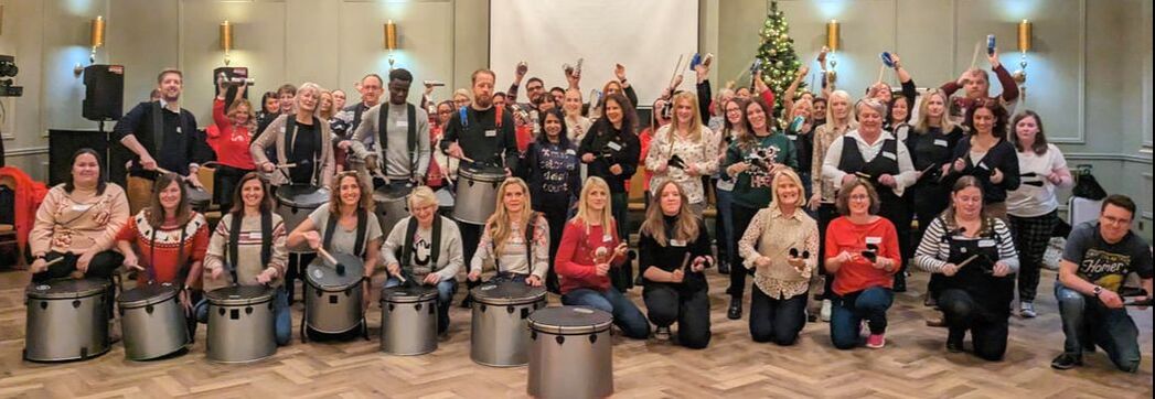 Staff group drumming at a business wellbeing event
