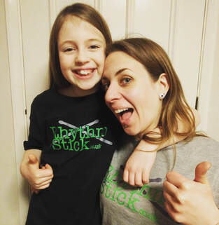 Katie Mallard and daughter in matching rhythm stick drumming t-shirts